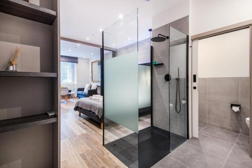 a glass shower in a room with a bedroom at Circlelet Luxury Private Suites in London