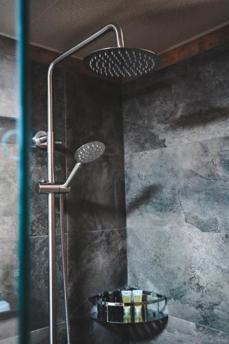 a shower with a shower head in a bathroom at Vaso-Levani Kazbegi Cottage in Kazbegi