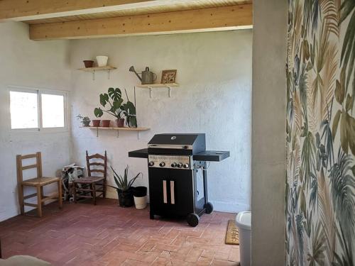 a kitchen with a stove and chairs in a room at La Casa del Chellero in Enguera