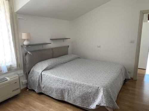 um quarto com uma cama num quarto branco em Casa Rino: Vacanze in casetta...... em Dongo
