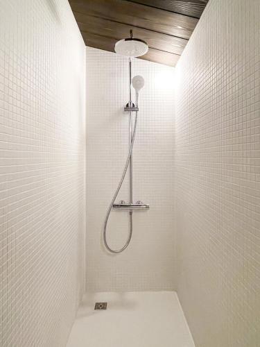 a bathroom with a shower in a white wall at Akizuki Kayabuki Kominka in Asakura