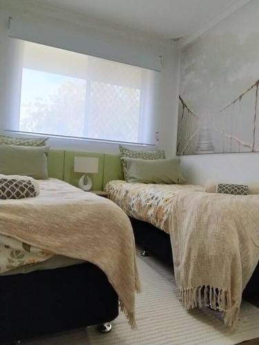a bedroom with two beds and a window at Modern Unit Near CBD & Beach, Free Parking in Perth