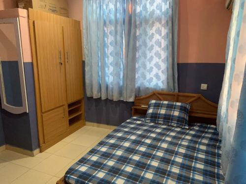 1 dormitorio con 1 cama con cuadros azules y blancos en Grace apartment, en Ofatedo