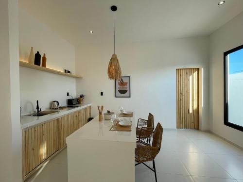 a kitchen with a white counter and a table at Casa com piscina privativa na Praia da Pipa #1 in Tibau do Sul