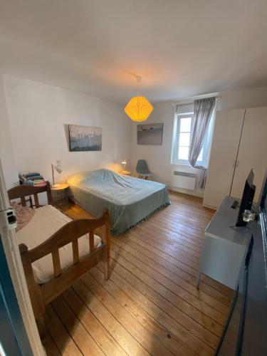 a bedroom with a bed and a desk and a window at Maison Plage à 50m, Centre Ville avec sa cabine de plage in Le Crotoy