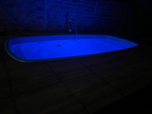 a blue bath tub in a dark room at Chalé meu príncipe in Marapanim