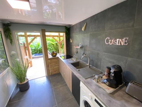 a kitchen with a sink and a counter at Kaz ananas, spa privatif ,plage du Helleux in Sainte-Anne
