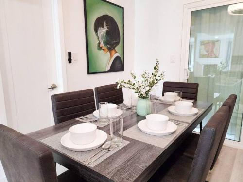 una mesa de comedor con sillas y una pintura en la pared en Stylish SD Living (10 min drive to Downtown and 15 min to beach) en Chula Vista