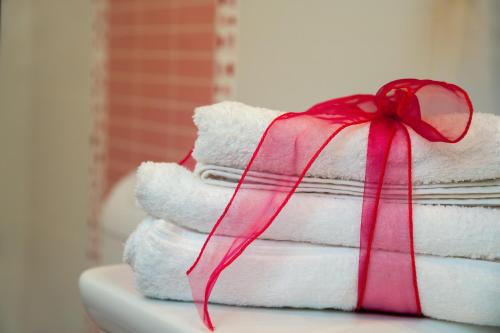 a stack of towels with a red bow on top at The Beach Studios & Apartments in Split