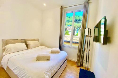 une chambre avec un lit blanc et une fenêtre dans l'établissement KEEP IN TOUCH 3 BEDROOM/3 BATHROOM/WIFI, à Cannes