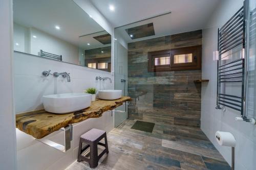 ein Badezimmer mit zwei Waschbecken auf einer Holzplatte in der Unterkunft Villa Mitjorn Cala Canyelles in Lloret de Mar