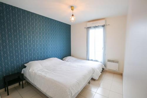 um quarto com 2 camas e uma parede azul em Lovely appt between Paris&Disney em Noisy-le-Grand