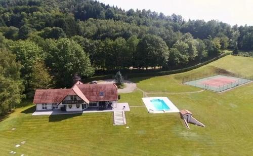 an aerial view of a house and a swimming pool at Villa Le Chant des Sapins - Tennis, Pool, Golf in Le Saulcy