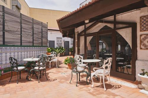 Un patio con mesas y sillas afuera de un edificio. en Mesón Castilla Atiram Hotels, en Barcelona