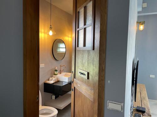 a bathroom with a sink and a toilet and a mirror at An Blue House in Dazhou