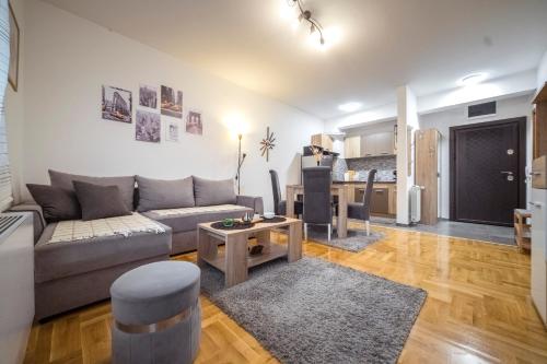 a living room with a couch and a table at Lux Apartmani Rakić in Pirot