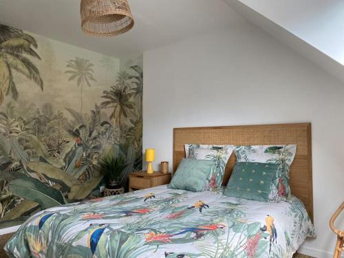 a bedroom with a bed with a tropical wallpaper at Agréable maison de ville avec jardin + garage. in Coulaines