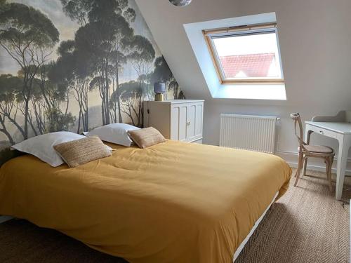 a bedroom with a large bed with a yellow blanket at Agréable maison de ville avec jardin + garage. in Coulaines