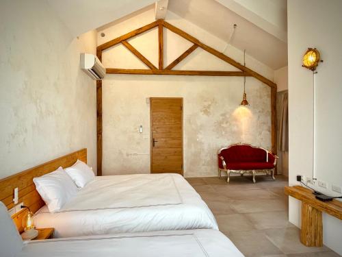 a bedroom with two beds and a red chair at An Blue House in Dazhou