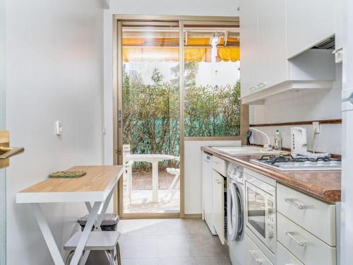 une cuisine blanche avec une table et un comptoir dans l'établissement Appartement 2 pièces pointe de la croisette, à Cannes