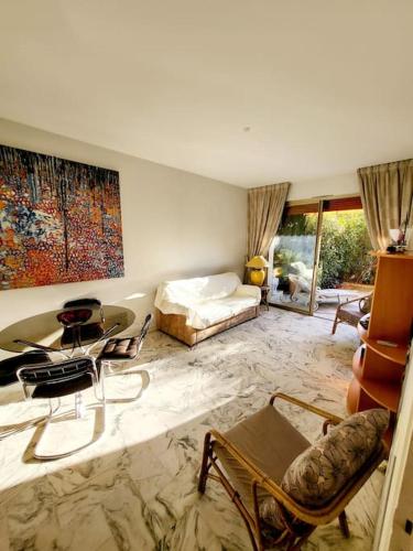 un salon avec un lit, une table et des chaises dans l'établissement Appartement 2 pièces pointe de la croisette, à Cannes