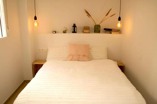 a bedroom with a large white bed in a room at Ca Lanosa in Alicante