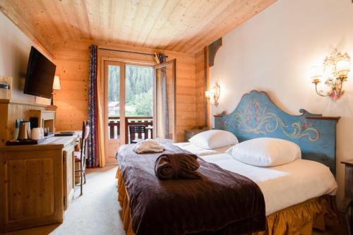 a bedroom with two beds and a desk in a room at La Maison Les Peupliers in Courchevel