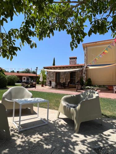 a group of chairs and a table under a tree at Espacio Shangrila.One in Uceda