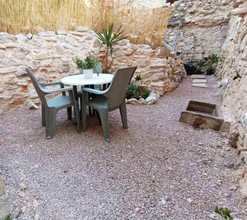 una mesa y sillas sentadas en un patio de grava en Εξοχική κατοικία στα Μαστιχοχώρια Χίου, en Chios