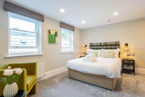 a bedroom with a large bed and a chair at Old Abbey House in Abingdon