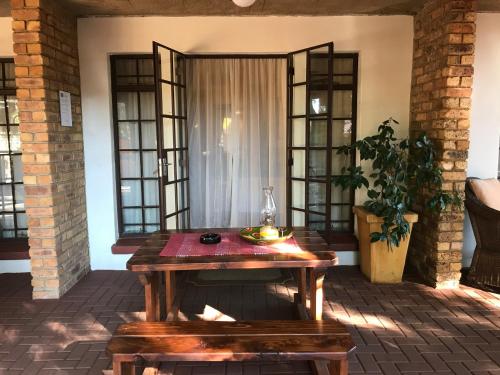 a wooden table in a room with windows at De Oude Herberg in Centurion