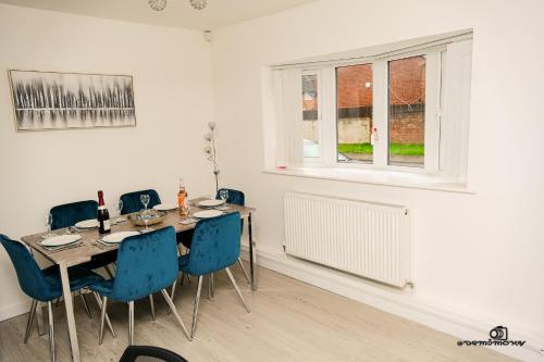 a dining room with a table and chairs and a window at Cosy home with private parking in Bloxwich