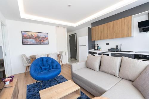 Trendy 2br Stylish, Vibrant Area في إسطنبول: غرفة معيشة مع أريكة وكرسي أزرق