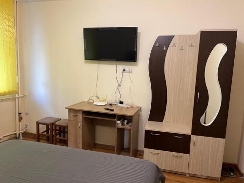 Zimmer mit einem Bett und einem Schreibtisch mit einem TV in der Unterkunft MEHTUP S.R.L. in Piteşti