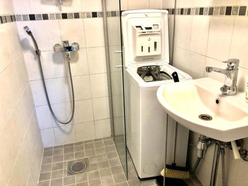 baño pequeño con ducha y lavamanos en Scandinavian Modern home 34 1BR City Center in Kamppi Työmiehenkatu, en Helsinki