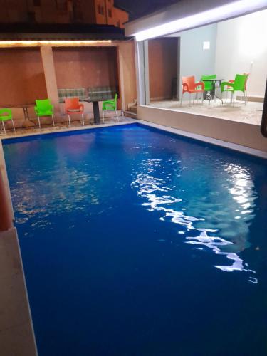 a swimming pool in a hotel with chairs and blue water at Apple Line Appartments in Mostar