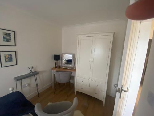 a room with a desk and a white cabinet at An Mordros 15 Polkirt Heights in Mevagissey