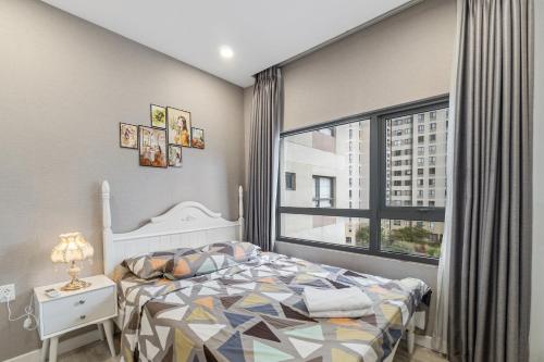 ein Schlafzimmer mit einem Bett und einem großen Fenster in der Unterkunft Cozy 2 Bedroom Condo in Masteri Thao Dien, Fully Furnished With Full Amenities in Ho-Chi-Minh-Stadt