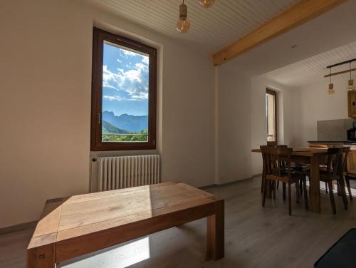 un salon avec une table et une fenêtre dans l'établissement Gîte Loubet, à Saint-Jacques-en-Valgodemard