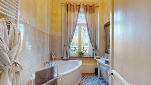 a bathroom with a tub and a window at Château "Le Castel des Anges" in Wailly-Beaucamp