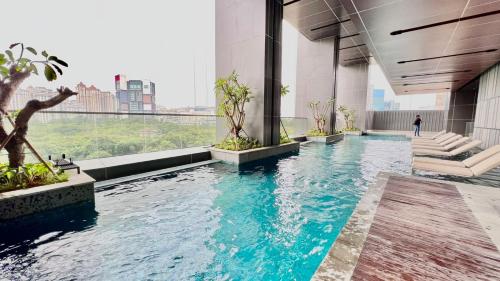 a swimming pool in the middle of a building at Condo with nearest to JIExpo 55” SMART TV (Netflix & Disney) and Wi-fi 50mb in Jakarta