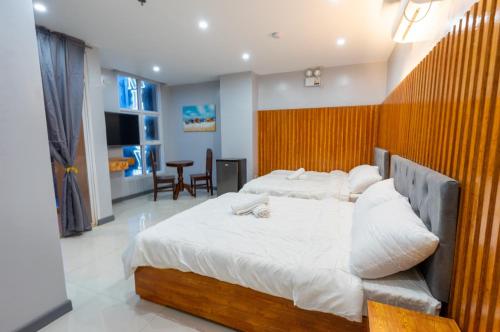 1 dormitorio con 2 camas, mesa y sillas en Grand Mercy Hotel, en Calbayog