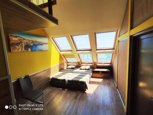 a bedroom with a bed in a room with windows at Happy Beach Rooms in Varna City