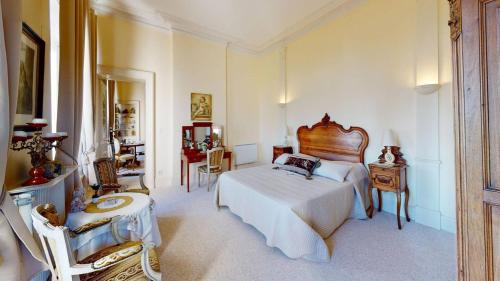 a bedroom with a bed and a table and chairs at Château "Le Castel des Anges" in Wailly-Beaucamp