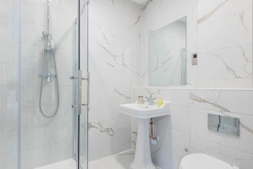a white bathroom with a sink and a shower at Old Abbey House in Abingdon