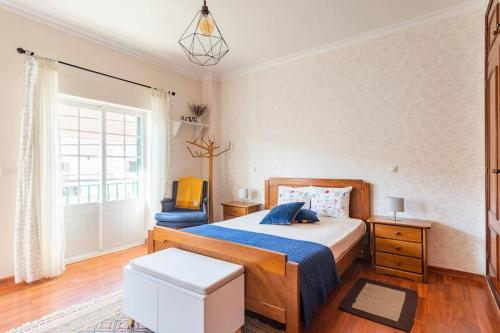 1 dormitorio con 1 cama y 1 silla azul en Suite Mendanha en Samora Correia
