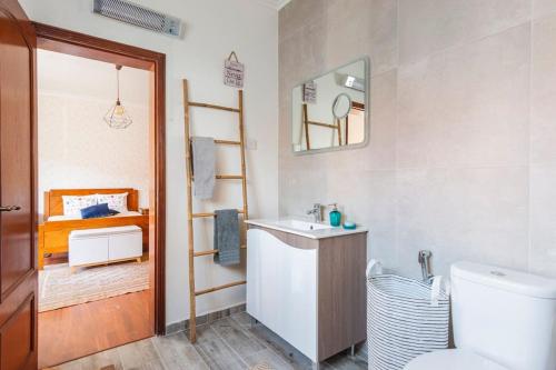 y baño con aseo, lavabo y espejo. en Suite Mendanha en Samora Correia
