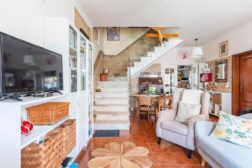 a living room with a staircase and a couch at Suite Mendanha in Samora Correia
