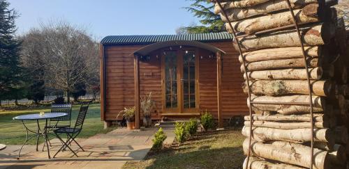 a log cabin with a table in a yard at Sika hut in Wareham