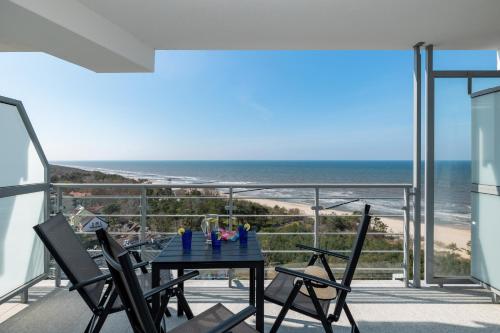 a table and chairs on a balcony with a view of the beach at Sea View Studio Apartment Porta Mare by Renters Prestige in Dziwnówek